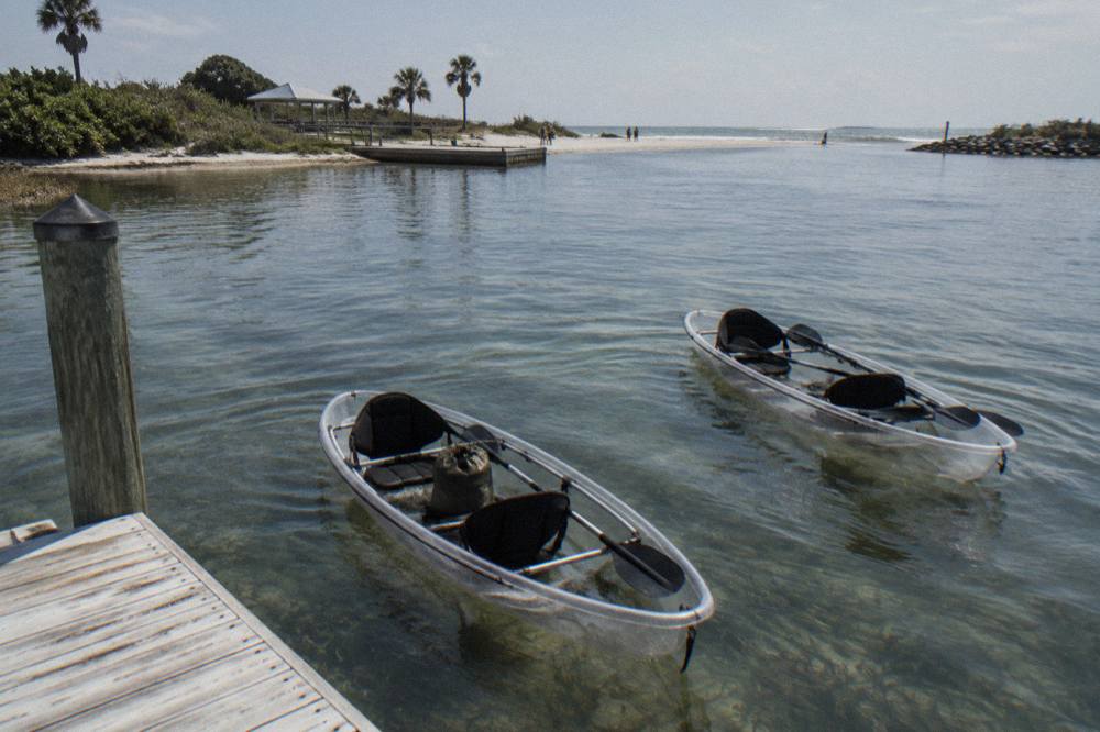 Two clear bottom kayaks drifting over shallow seagrass beds in a calm lagoon