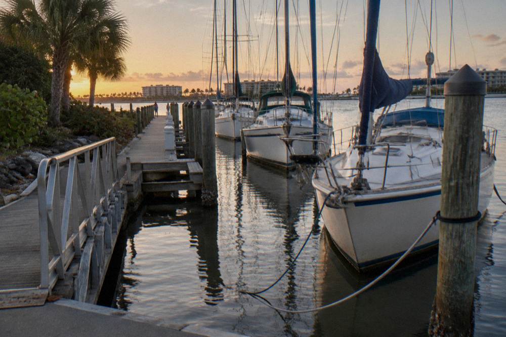 Marina docks with sailboats moored along a calm river channel