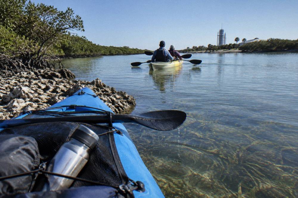 Tandem kayaks floating over shallow seagrass beds in a lagoon channel