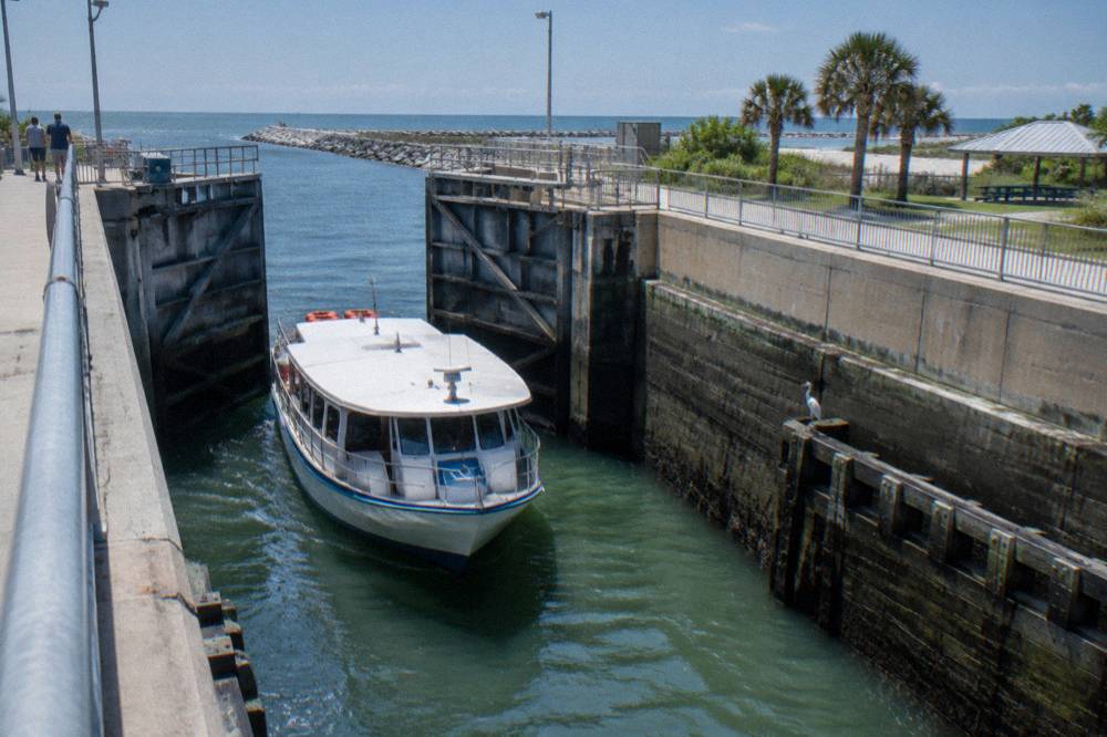 Passenger boat passing through a canal lock with raised gates